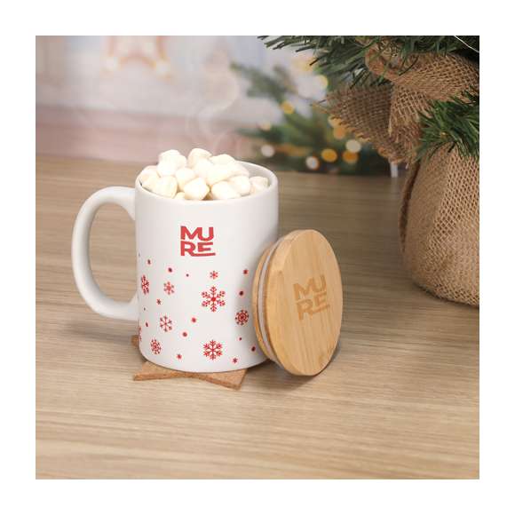 Taza de cerámica con 300 ml de capacidad. Distinguido diseño navideño con copos de nieve, disponible en dos combinaciones de rojo y blanco mate. Incluye tapadera fabricada en suave bambú. Materiales como el bambú fomentan la utilización de materias primas naturales reduciendo las emisiones contaminantes. Además, el bambú proviene de una planta de gran resistencia y versatilidad, con crecimiento y regeneración rápida, siendo una excelente alternativa al uso de madera tradicional.