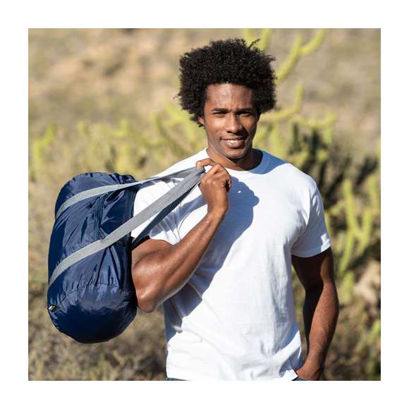 Bolso multiusos en suave poliéster 290T RPET, elaborado a partir de plástico reciclado, para así fomentar la reutilización de residuos plásticos y ayudar a la sostenibilidad del planeta. En desenfadado diseño bicolor retro, con bolsillo principal y frontal con cierres de cremallera y tiradores con cuerdas. Resistentes asas de nylon en contraste alrededor del cuerpo en color gris. Disponible en variada gama de colores, con distintivo RPET en etiqueta.