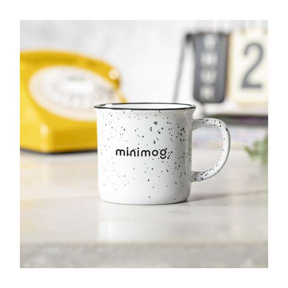 Taza de cerámica de 350ml de capacidad con diseño vintage. En combinación de exterior en colores moteados e interior a juego, con borde negro. Presentada en caja individual acabado kraft.