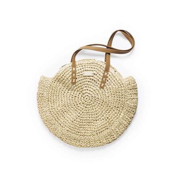Bolso de desenfadado diseño en rafia sintética y con forma circular, un must. Compartimento principal de cierre de cremallera y tirador metálico, con bolsillo en el interior. Forro interior y asas largas en PU, con triple refuerzo en X y superficie para personalización en madera, especialmente diseñada para marcaje en láser.