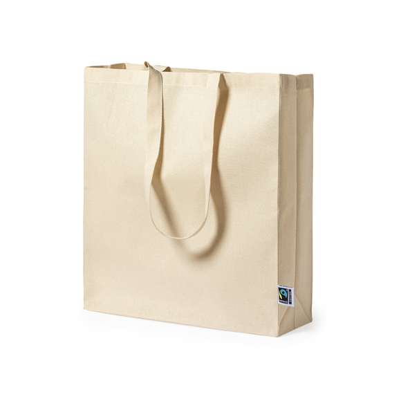 Bolsa de línea nature, fabricada en 100% algodón de 180g/m2 en tono natural. Con certificación Fairtrade (Comercio Justo) un sistema comercial solidario y alternativo al convencional que persigue el desarrollo de los pueblos y la lucha contra la pobreza. De acabado cosido con fuelle, asas largas reforzadas de 70cm y resistencia hasta 7kg de peso. Incluida etiqueta Fairtrade y hangtag distintivo en cartón reciclado.