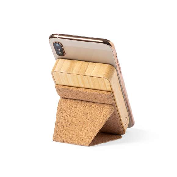 Batería auxiliar externa de línea nature, fabricada en bambú y con soporte en corcho natural. De 5.000 mAh de capacidad de carga, con cargador inalámbrico integrado 15W y fijación magnética para poder usar el dispositivo mientras se está cargando. Conector de entrada y salida Tipo C + salida USB. Incluye anillo adhesivo, siendo válido para todos los dispositivos con tecnología Magsafe y Qi. Presentada en caja individual de diseño eco en cartón kraft.Las capacidades mostradas en todas nuestras baterías auxiliares externas son reales, incorporando todas ellas baterías de grado A y no recicladas, con una vida útil de al menos 500 ciclos de carga y según normativa CE. Además, están fabricadas conforme a los estándares RoHS y en cumplimiento con los siguientes requisitos de seguridad: Sistema de protección contra sobrecarga del power bank. Sistema de protección contra descarga completa que proporciona una mayor durabilidad del power bank. Sistema de bloqueo para evitar cortocircuitos. Sistema de transferencia de carga constante, acorde con la capacidad del dispositivo de destino.