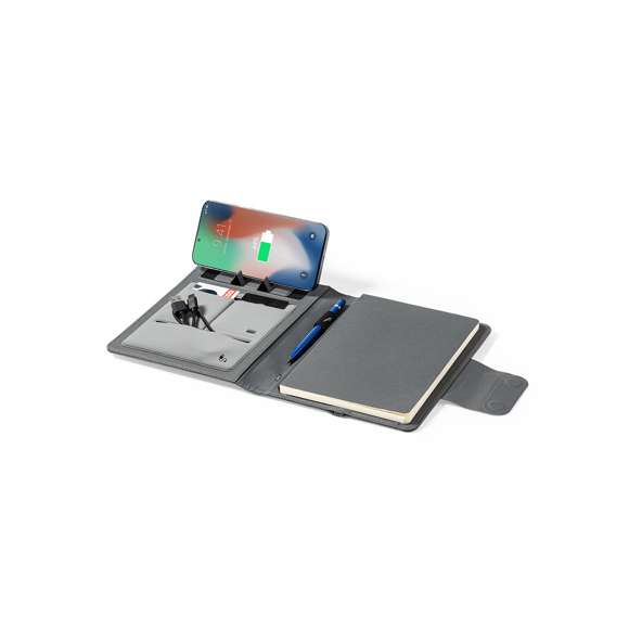 Carpeta/bloc multifunción fabricada en poliéster 300D RPET, elaborado a partir de plástico reciclado, para así fomentar la reutilización de residuos plásticos y ayudar a la sostenibilidad del planeta. Con cierre magnético y etiqueta interior con distintivo RPET.  Incluye cargador inalámbrico 10W integrado en portada, con fijación magnética para poder usar el dispositivo mientras se produce la carga del mismo e incluyendo anillo adhesivo, válido para todos los dispositivos con tecnología Magsafe y Qi.  Batería integrada de 5.000 mAh de capacidad de carga, con puerto Tipo C de entrada/salida y LEDs indicadores de estado de carga, con cable incluido.  Interior con soporte para smartphone y multitud de compartimentos para tarjetas, incluidos soporte para bolígrafo y bloc A5 con 65 hojas de disposición a una raya.  Presentada en atractiva caja individual de diseño.  Las capacidades mostradas en todas nuestras baterías auxiliares externas son reales, incorporando todas ellas baterías de grado A y no recicladas, con una vida útil de al menos 500 ciclos de carga y según normativa CE. Además, están fabricadas conforme a los estándares RoHS y en cumplimiento con los siguientes requisitos de seguridad:  Sistema de protección contra sobrecarga del power bank. Sistema de protección contra descarga completa que proporciona una mayor durabilidad del power bank. Sistema de bloqueo para evitar cortocircuitos. Sistema de transferencia de carga constante, acorde con la capacidad del dispositivo de destino.