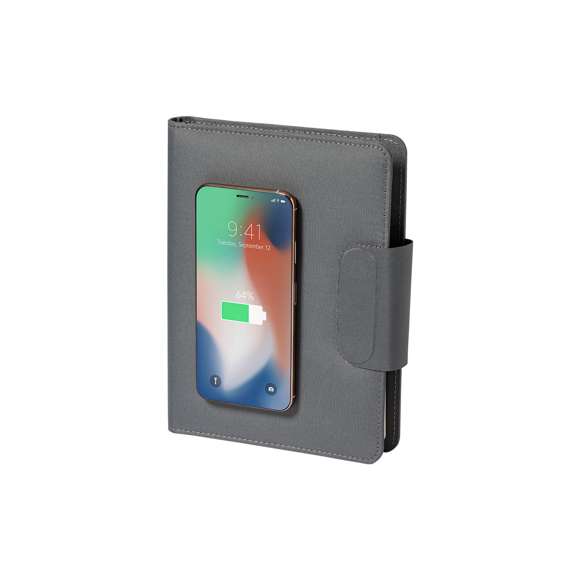Carpeta/bloc multifunción fabricada en poliéster 300D RPET, elaborado a partir de plástico reciclado, para así fomentar la reutilización de residuos plásticos y ayudar a la sostenibilidad del planeta. Con cierre magnético y etiqueta interior con distintivo RPET.  Incluye cargador inalámbrico 10W integrado en portada, con fijación magnética para poder usar el dispositivo mientras se produce la carga del mismo e incluyendo anillo adhesivo, válido para todos los dispositivos con tecnología Magsafe y Qi.  Batería integrada de 5.000 mAh de capacidad de carga, con puerto Tipo C de entrada/salida y LEDs indicadores de estado de carga, con cable incluido.  Interior con soporte para smartphone y multitud de compartimentos para tarjetas, incluidos soporte para bolígrafo y bloc A5 con 65 hojas de disposición a una raya.  Presentada en atractiva caja individual de diseño.  Las capacidades mostradas en todas nuestras baterías auxiliares externas son reales, incorporando todas ellas baterías de grado A y no recicladas, con una vida útil de al menos 500 ciclos de carga y según normativa CE. Además, están fabricadas conforme a los estándares RoHS y en cumplimiento con los siguientes requisitos de seguridad:  Sistema de protección contra sobrecarga del power bank. Sistema de protección contra descarga completa que proporciona una mayor durabilidad del power bank. Sistema de bloqueo para evitar cortocircuitos. Sistema de transferencia de carga constante, acorde con la capacidad del dispositivo de destino.