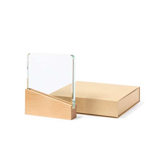 Placa conmemorativa fabricada en cristal grueso y resistente, con base en madera natural. Presentada en estuche de protección kraft, con cierre magnético y espuma interior.