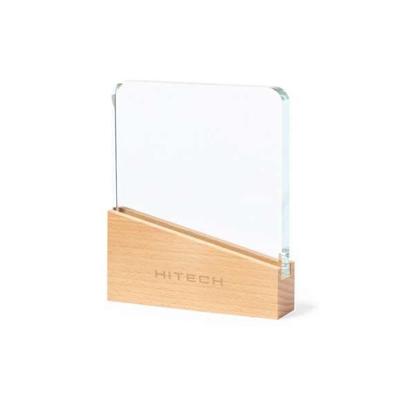 Placa conmemorativa fabricada en cristal grueso y resistente, con base en madera natural. Presentada en estuche de protección kraft, con cierre magnético y espuma interior.