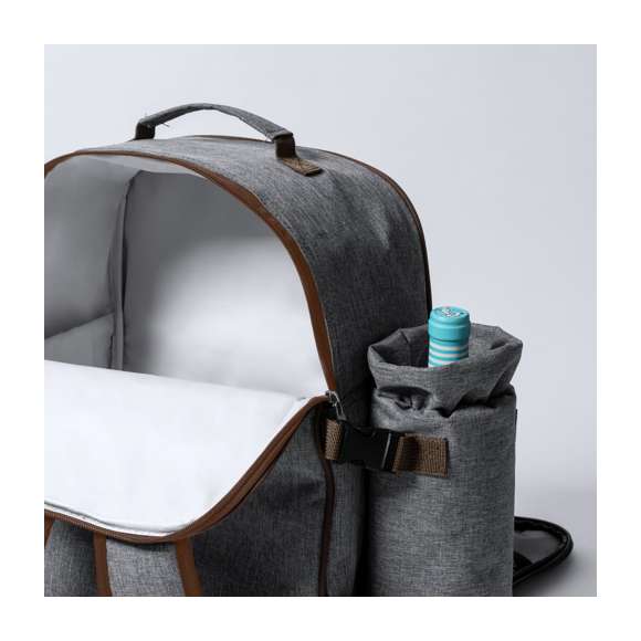 Mochila nevera para picnic de 4 servicios y con multitud de complementos, fabricada en resistente 600D RPET. Acabado en color gris, con detalles en marrón asa de transporte y cintas para hombros acolchadas y ajustables. Compartimento principal con cierre de cremallera y tiradores metálicos. Interior isotermo en PEVA y etiqueta exterior con distintivo RPET. Incluye:  4 tazas en acero inox. 4 cucharas, 4 cuchillos y 4 tenedores en acero inox con mango en PP blanco. 1 cuchillo de untar en acero inox con mango en PP blanco 4 platos en PP blanco de 23 cm de diámetro. 4 servilletas en tela de 30 x 30 cm. Con diseño retro en patrón a cuadros y en combinación tonos negros, grises y blancos. Sacacorchos abridor en acero inox con mango en PP blanco. Salero y pimentero transparentes con tapón en PP blanco. Tabla de corte y presentación en madera, tamaño 15x15 cm. Bolsa plegable interior. Botellero térmico a juego en lateral izquierdo, fabricado en RPET y extraíble mediante cierres de hebilla. Manta de picnic de calidad premium lateral derecho, con cierres ajustables de hebilla. Medidas 120x150cm, con lado para sentarse en patrón tartán bicolor de agradable tacto. Base aislante en resistente PEVA. De fácil plegado y de tamaño compacto, incluye asa de transporte y solapa con cierre de velcro.  El material RPET se elabora a partir de plástico reciclado, para así fomentar la reutilización de residuos plásticos y ayudar a la sostenibilidad del planeta.