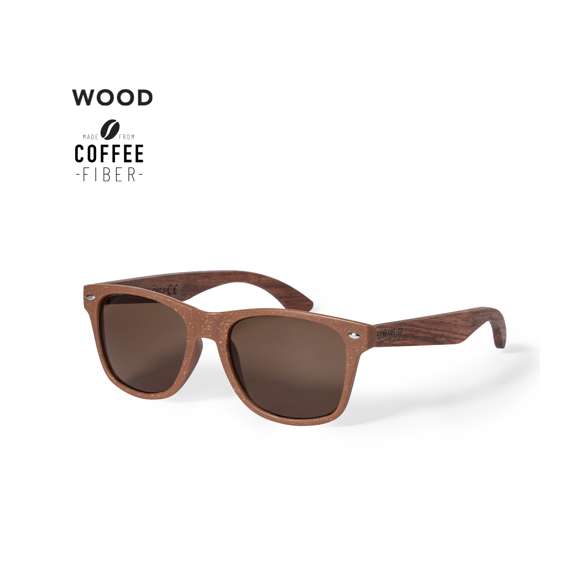Gafas de sol de línea nature con protección UV 400. Montura fabricada en fibra de café y patillas en madera natural a juego, con lentes en tono marrón. Distintivo fibra de café inyectado en molde de patilla izquierda. Presentación en caja individual de diseño kraft.La fibra de café es una solución circular que se obtiene de la utilización de los residuos producidos en la obtención del café. Una alternativa sostenible que favorece la reducción del uso de plásticos, ahorrando energía en su proceso de fabricación y contribuyendo al cuidado del medio ambiente.