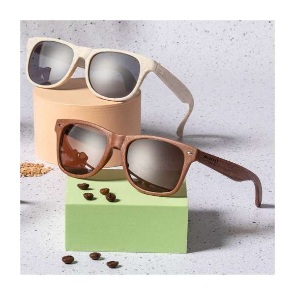 Gafas de sol de línea nature con protección UV 400. Montura fabricada en fibra de café y patillas en madera natural a juego, con lentes en tono marrón. Distintivo fibra de café inyectado en molde de patilla izquierda. Presentación en caja individual de diseño kraft.La fibra de café es una solución circular que se obtiene de la utilización de los residuos producidos en la obtención del café. Una alternativa sostenible que favorece la reducción del uso de plásticos, ahorrando energía en su proceso de fabricación y contribuyendo al cuidado del medio ambiente.