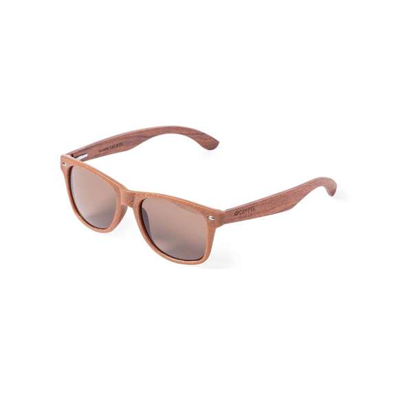 Gafas de sol de línea nature con protección UV 400. Montura fabricada en fibra de café y patillas en madera natural a juego, con lentes en tono marrón. Distintivo fibra de café inyectado en molde de patilla izquierda. Presentación en caja individual de diseño kraft.La fibra de café es una solución circular que se obtiene de la utilización de los residuos producidos en la obtención del café. Una alternativa sostenible que favorece la reducción del uso de plásticos, ahorrando energía en su proceso de fabricación y contribuyendo al cuidado del medio ambiente.