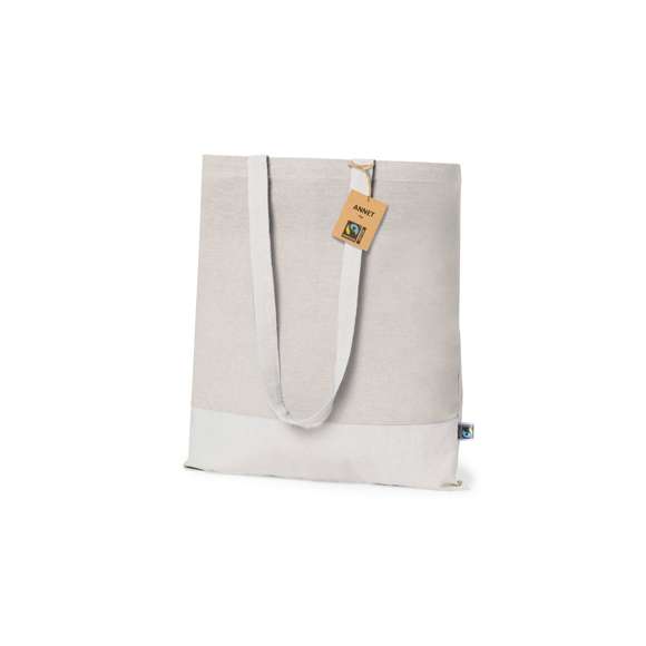 Bolsa de línea nature, fabricada en algodón 100% de 140g/m2. Con certificación Fairtrade (Comercio Justo), un sistema comercial solidario y alternativo al convencional que persigue el desarrollo de los pueblos y la lucha contra la pobreza. De acabado cosido y asas largas reforzadas  con base en tono natural y parte frontal superior disponible en tonos negro y natural. Incluida etiqueta Fairtrade y hangtag distintivo en cartón reciclado.