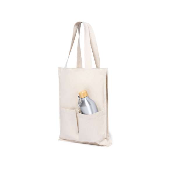 Bolsa fabricada en algodón 100%, de acabado natural y en gramaje extra de 310g/m2. Con dos bolsillos exteriores, de acabado cosido y con fuelle. Asas medianas extra anchas y reforzadas (58 x 3,5 cm). Resistencia hasta 10 kg de peso.