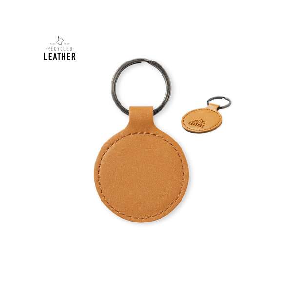 Llavero de línea nature fabricado en cuero reciclado. En tono marrón, con diseño circular y de acabado cosido. Grabado con distintivo cuero reciclado en una cara, con lado opuesto liso para impresión. Anilla metálica cromada y presentado en bolsa individual kraft.El cuero reciclado rescata las fibras desechadas en los procesos de fabricación del cuero, minimizando el desperdicio de material, contribuyendo a reducir el impacto ambiental y manteniendo a la vez sus propiedades originales.