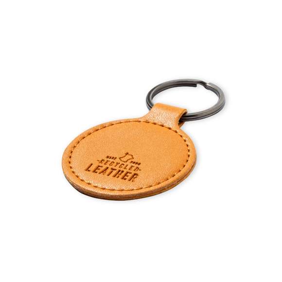 Llavero de línea nature fabricado en cuero reciclado. En tono marrón, con diseño circular y de acabado cosido. Grabado con distintivo cuero reciclado en una cara, con lado opuesto liso para impresión. Anilla metálica cromada y presentado en bolsa individual kraft.El cuero reciclado rescata las fibras desechadas en los procesos de fabricación del cuero, minimizando el desperdicio de material, contribuyendo a reducir el impacto ambiental y manteniendo a la vez sus propiedades originales.