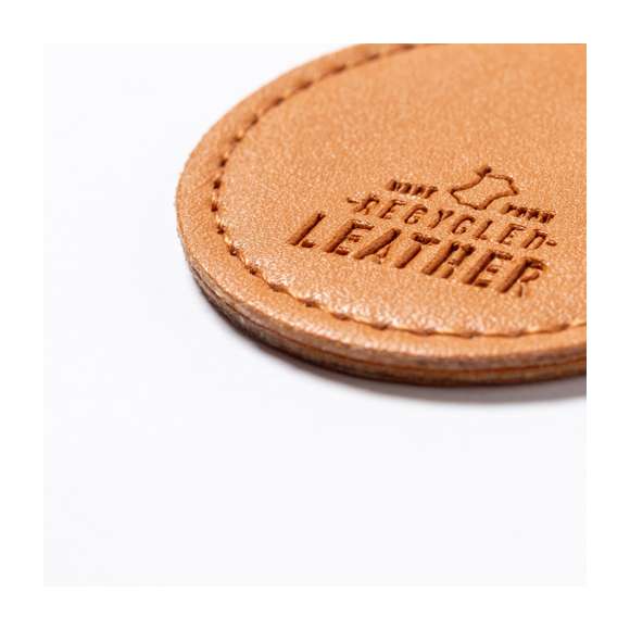 Llavero de línea nature fabricado en cuero reciclado. En tono marrón, con diseño circular y de acabado cosido. Grabado con distintivo cuero reciclado en una cara, con lado opuesto liso para impresión. Anilla metálica cromada y presentado en bolsa individual kraft.El cuero reciclado rescata las fibras desechadas en los procesos de fabricación del cuero, minimizando el desperdicio de material, contribuyendo a reducir el impacto ambiental y manteniendo a la vez sus propiedades originales.
