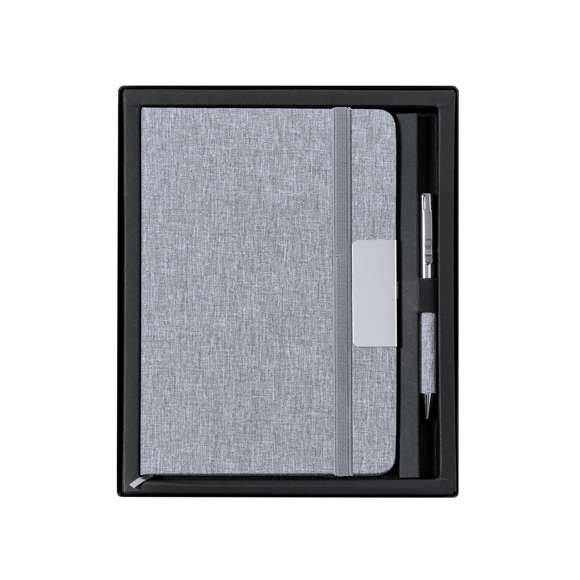 Set de bloc de notas y bolígrafo en RPET, elaborado a partir de plástico reciclado para así fomentar la reutilización de residuos plásticos y ayudar a la sostenibilidad del planeta. Incluye: Bloc de notas de tapas rígidas, con detalle metálico en la portada, marcapáginas de tela y elástico de sujeción a juego. 100 hojas interiores con disposición a una raya y distintivo RPET.Bolígrafo fabricado en metal cromado y con cuerpo recubierto en poliéster RPET. Elegante clip metálico y accesorios a juego, de mecanismo giratorio y en tinta azul. Con distintivo RPET en cuerpo.Set presentado en elegante estuche de diseño en color negro, con compartimento independiente para bloc de notas y bolígrafo.