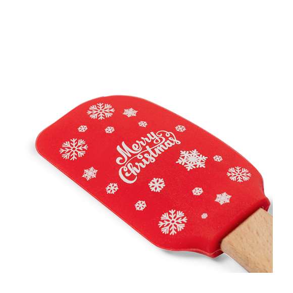 Paleta de cocina con extremo de silicona y originales motivos navideños. Confortable mango fabricado en madera natural. Presentado en bolsa individual reciclada.
