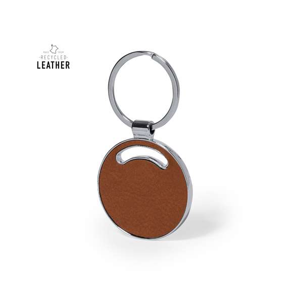 Llavero fabricado en cuero reciclado. En tono marrón, incluye distintivo cuero reciclado en una cara, con lado opuesto liso para impresión y anilla metálica cromada. Disponible en cuatro diseños:A: CasaB: CocheC: CírculoD: RectánguloPresentado en bolsa individual reciclada de cartón kraft.El cuero reciclado rescata las fibras desechadas en los procesos de fabricación del cuero, minimizando el desperdicio de material, contribuyendo a reducir el impacto ambiental y manteniendo a la vez sus propiedades originales.