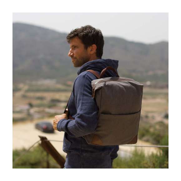 Mochila de diseño atemporal, fabricada en resistente canvas de 475g/m2 de color gris, con cremalleras y asa de transporte en polipiel. Interior acolchado con compartimentos independientes para tablet de hasta 10 pulgadas y ordenador portátil de hasta 15 pulgadas. Con práctico bolsillo frontal en el exterior, espalda acolchada y cintas para hombros ajustables y acolchadas en resistente poliéster. Con esquinas reforzadas para una mayor resistencia.Presentado en bolsa individual reciclada.