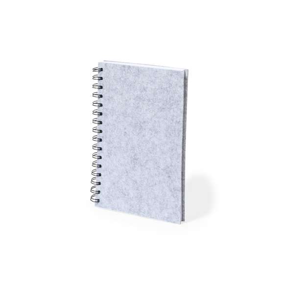 Libreta de anillas con tapas en suave fieltro RPET reciclado. Interior con 100 hojas blancas con disposición a una raya. Incluye distintivo RPET. Presentado en bolsa individual reciclada.El fieltro RPET reciclado es fruto de la combinación del proceso de reciclaje de materiales plásticos junto a la técnica milenaria de fabricación del fieltro, dando como resultado un material de eco-tendencia que, además de ser de origen reciclado, también se convierte en reciclable.