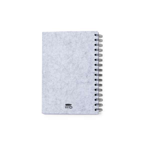 Libreta de anillas con tapas en suave fieltro RPET reciclado. Interior con 100 hojas blancas con disposición a una raya. Incluye distintivo RPET. Presentado en bolsa individual reciclada.El fieltro RPET reciclado es fruto de la combinación del proceso de reciclaje de materiales plásticos junto a la técnica milenaria de fabricación del fieltro, dando como resultado un material de eco-tendencia que, además de ser de origen reciclado, también se convierte en reciclable.