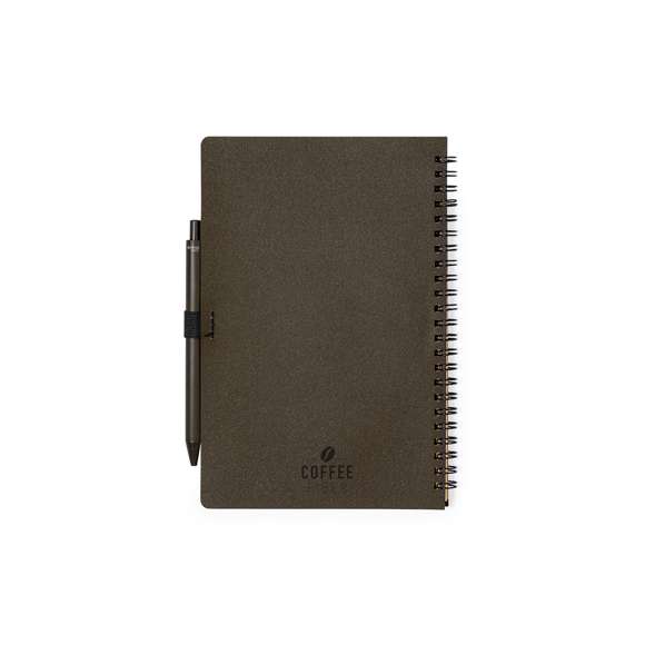 Set de libreta y bolígrafo. Libreta de anillas con tapas fabricadas en suave fibra de café y soporte para el bolígrafo. De 80 hojas con diseño eco y disposición a una raya. Bolígrafo de mecanismo pulsador, con cuerpo en fibra de café y tinta azul. Incluye distintivo fibra de café impreso en libreta y bolígrafo. Presentado en bolsa individual reciclada.La fibra de café se elaborada a partir de los residuos producidos en la obtención del café. Una alternativa sostenible que favorece la reducción del uso de plásticos, ahorrando energía en el proceso de fabricación y fomentando así el cuidado del medio ambiente.