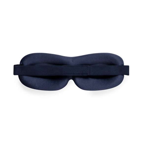 Cómoda máscara de viaje fabricada en suave poliéster. Máxima experiencia de descanso para los ojos, debido a que su diseño acolchado proporciona un bloqueo óptimo de la luz para un sueño reparador en cualquier lugar. El elástico regulable garantiza un ajuste cómodo y seguro. Presentado en bolsa individual de papel reciclado.
