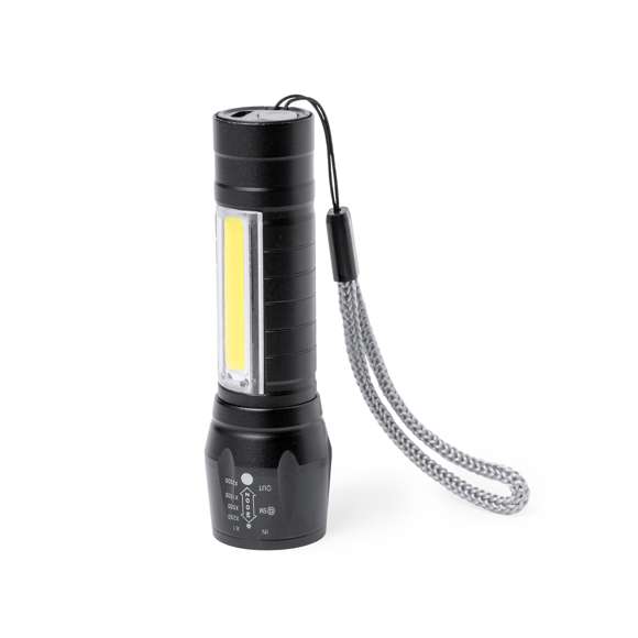 Potente linterna con batería recargable, fabricada en aluminio de acabado en color negro. Luz frontal con 1 LED y cabezal regulable, para tener un enfoque más focalizado o abierto. Además, cuenta con 10 luces COB en el mango y tres modos de iluminación (fija e intermitente de dos velocidades), incluye cinta de trasporte. Se alimenta mediante una batería recargable de 400 mAh, incluido cable micro USB. Presentada individualmente en caja de diseño.