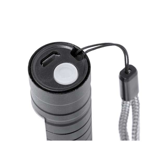 Potente linterna con batería recargable, fabricada en aluminio de acabado en color negro. Luz frontal con 1 LED y cabezal regulable, para tener un enfoque más focalizado o abierto. Además, cuenta con 10 luces COB en el mango y tres modos de iluminación (fija e intermitente de dos velocidades), incluye cinta de trasporte. Se alimenta mediante una batería recargable de 400 mAh, incluido cable micro USB. Presentada individualmente en caja de diseño.