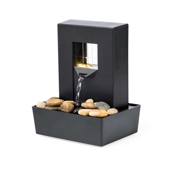 Fuente portátil de agua infinita con luces LED. Cascada de agua sobre piedras naturales, ideal para decoración o momentos de relajación. Incluye un depósito para el agua y una estructura iluminada por LEDs de tonos naturales, a través de la que fluye el agua. Alimentada por 3 pilas AA (no incluidas). Presentada en caja de diseño kraft.