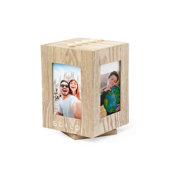 Original portafotos cubo fabricado en madera natural. Su diseño en forma de cubo permite mostrar las 4 fotos más destacadas del álbum y, además, cuenta con una base giratoria 360º. Ideal para fotos de hasta 13,5x9 cm. Presentado en caja individual de diseño kraft.
