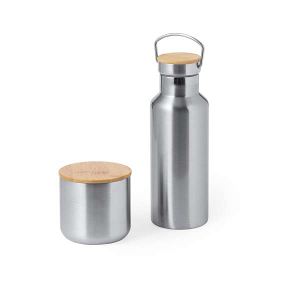 Práctico set de bidón y vaso térmico en acero inox. Incluye, bidón térmico de 500 ml de capacidad fabricado en acero inox, tapón de seguridad a rosca con base de bambú e incluye asa de transporte. Además, contiene 1 vaso de 300 ml de capacidad en acero inox y tapadera bambú con cierre de presión. Presentado en una caja de diseño kraft.