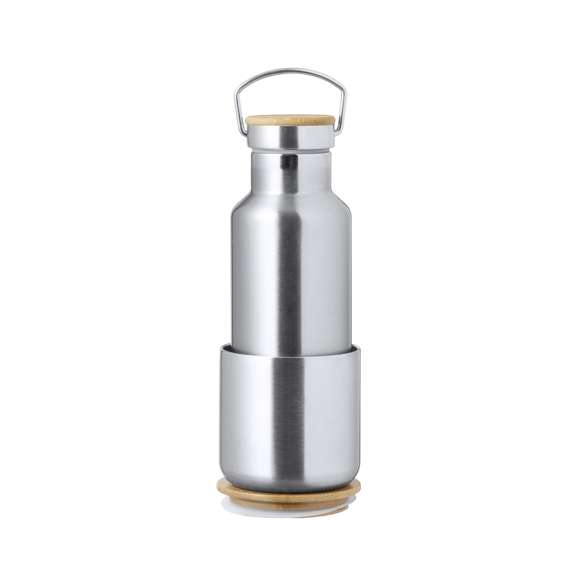 Práctico set de bidón y vaso térmico en acero inox. Incluye, bidón térmico de 500 ml de capacidad fabricado en acero inox, tapón de seguridad a rosca con base de bambú e incluye asa de transporte. Además, contiene 1 vaso de 300 ml de capacidad en acero inox y tapadera bambú con cierre de presión. Presentado en una caja de diseño kraft.