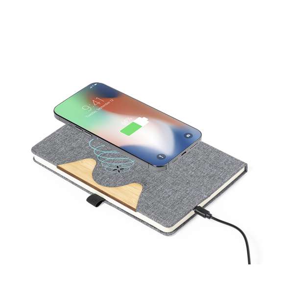 Bloc de notas cargador tamaño A5 y fabricado en resistente poliéster 300D RPET. Portada con detalle en bambú y cargador inalámbrico de 15W integrado, compatible con smartphones con tecnología de carga inalámbrica. Incluido cable de carga Tipo C y disponible manual de instrucciones en español e inglés. Con 80 hojas interiores de disposición a una raya y presentado en bolsa de papel reciclado. El material RPET se elabora a partir de plástico reciclado, para así fomentar la reutilización de residuos plásticos y ayudar a la sostenibilidad del planeta.Materiales como el bambú fomentan la utilización de materias primas naturales, reduciendo las emisiones contaminantes. Proviene de una planta de gran resistencia y versatilidad, con crecimiento y regeneración rápidos, siendo una excelente alternativa al uso de madera tradicional.Fabricado conforme a los estándares RoHS y en cumplimiento con los siguientes requisitos de seguridad: Sistema de protección contra sobrecalentamiento. Sistema de protección contra sobrecarga. Sistema de bloqueo para evitar cortocircuitos.