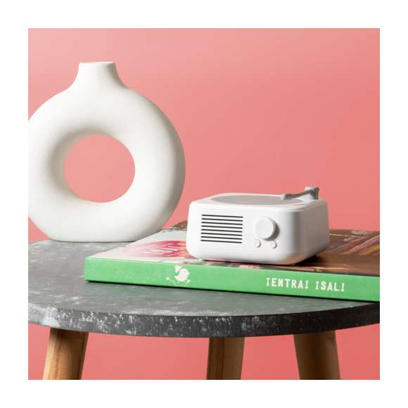 Altavoz Bluetooth en original forma de tocadiscos, de tamaño compacto y 5W de potencia. Batería de litio de 800mAh, con cable de carga Tipo C incluido e indicador luminoso de estado de carga. Función manos libres y radio FM, con ranura para tarjetas micro SD de hasta 32 GB de capacidad y una entrada auxiliar para conector jack de 3,5 mm. Fabricado en resistente ABS blanco con detalles en gris y presentado en caja individual de diseño kraft, con manual de instrucciones en español e inglés.