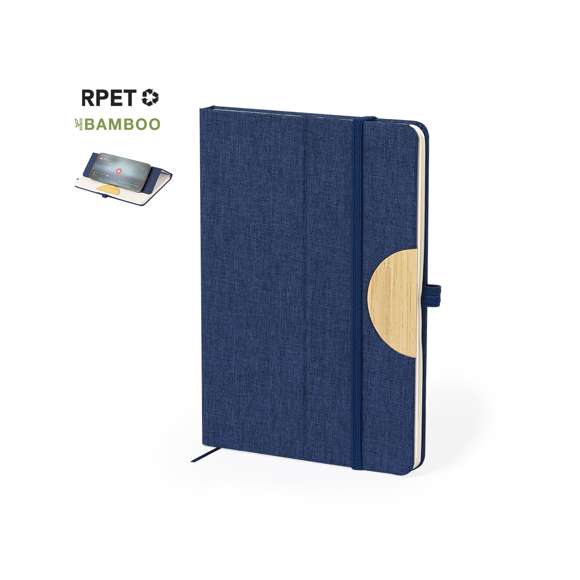Bloc de notas soporte con tapas rígidas fabricado en RPET 300D y bambú. Versátil soporte integrado en la portada para smartphone y tablet, confeccionado en bambú. Cuenta con elástico de cierre y soporte para bolígrafo a juego. Contiene 80 hojas interiores lisas y está disponible en una amplia gama de colores. Con logotipo RPET en contraportada y presentado en bolsa individual de papel reciclada.El material RPET se elabora a partir de plástico reciclado, para así fomentar la reutilización de residuos plásticos y ayudar a la sostenibilidad del planeta.