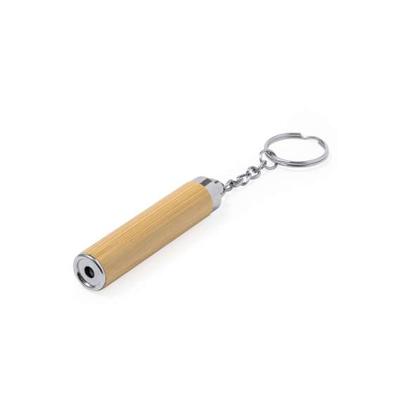 Llavero linterna fabricado en bambú. Con 1 LED alimentado con pila botón (incluida) y presentado en caja de diseño kraft.Materiales como el bambú fomentan la utilización de materias primas naturales, reduciendo las emisiones contaminantes. Proviene de una planta de gran resistencia y versatilidad, con crecimiento y regeneración rápidos, siendo una excelente alternativa al uso de madera tradicional.