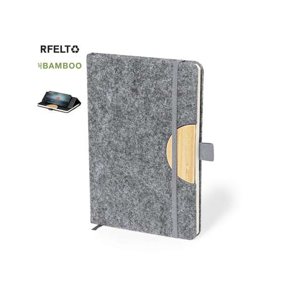 Bloc de notas con soporte de tapas rígidas fabricado en fieltro RPET 300D. Con original soporte para smartphone y tablet integrado en la portada, fabricado en bambú. Incluye elástico de cierre y soporte para bolígrafo a juego, con 80 hojas interiores de disposición a una raya. Con logotipo RPET en contraportada y presentada en bolsa individual reciclada.El fieltro RPET es fruto de la combinación del proceso de reciclaje de materiales plásticos junto con la técnica milenaria de fabricación del fieltro, dando como resultado un material de eco-tendencia que, además de ser de origen reciclado, también se convierte en reciclable.