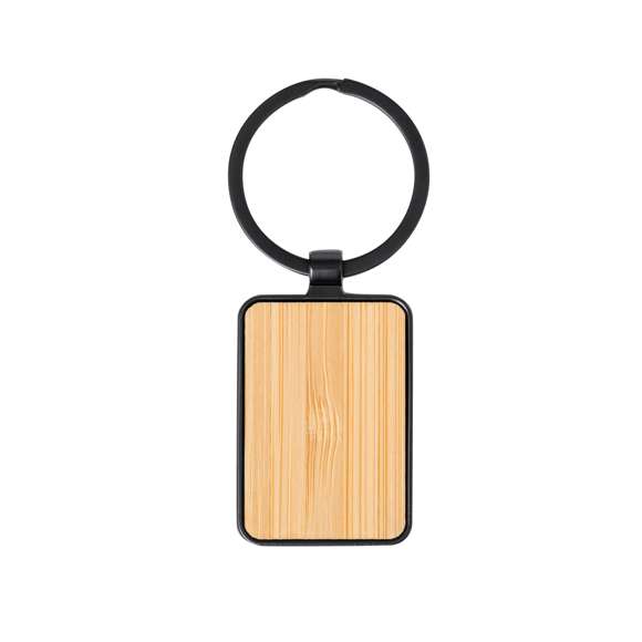 Llavero de elegante diseño, fabricado en metal pulido de color negro, con una cara en suave bambú. Especialmente diseñado par marcaje en láser y disponible en diseño rectangular y circular. Presentado individualmente bolsa de papel reciclado.