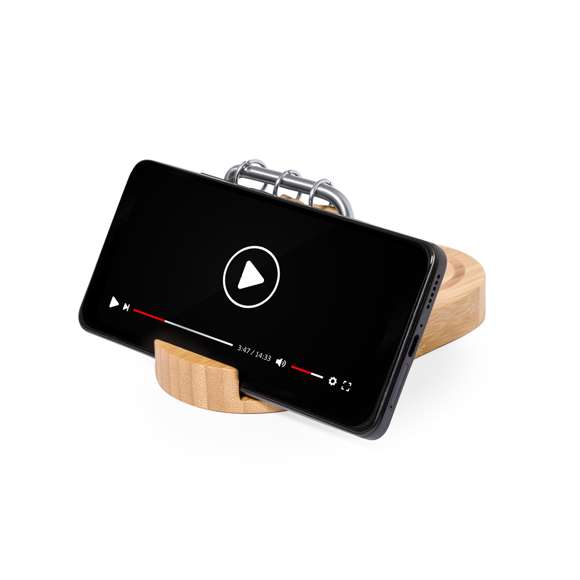 Cargador multifunción inalámbrico 15W fabricado en bambú. Incluye soporte para smartphone y calendario perpetuo, además de un bloc con 50 notas adhesivas acabado kraft de 4,5x4,5 cm. Salida USB y entrada y salida Tipo C, permitiendo cargar de manera simultánea hasta 3 dispositivos (1 mediante carga inalámbrica, 1 mediante cable Tipo C y 1 por cable USB). Compatible con dispositivos equipados con tecnología de carga inalámbrica. Amplia superficie de marcaje y presentado en caja individual de diseño kraft.Materiales como el bambú fomentan la utilización de materias primas naturales, reduciendo las emisiones contaminantes. Proviene de una planta de gran resistencia y versatilidad, con crecimiento y regeneración rápidos, siendo una excelente alternativa al uso de madera tradicional.Fabricado conforme a los estándares RoHS y en cumplimiento con los siguientes requisitos de seguridad:Sistema de protección contra sobrecalentamiento.Sistema de protección contra sobrecarga.Sistema de bloqueo para evitar cortocircuitos.