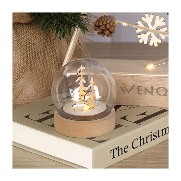 Bola iluminada con original diseño navideño. Elaborada en resistente material acrílico, con base de madera lisa para impresión. Dispone de iluminación interior con 1 LED en tono blanco. Alimentación por 3 pilas de botón, incluidas, con botón ON/OFF en la base. Elaborado con elementos vegetales para así fomentar la utilización de materias primas naturales y reducir las emisiones contaminantes.