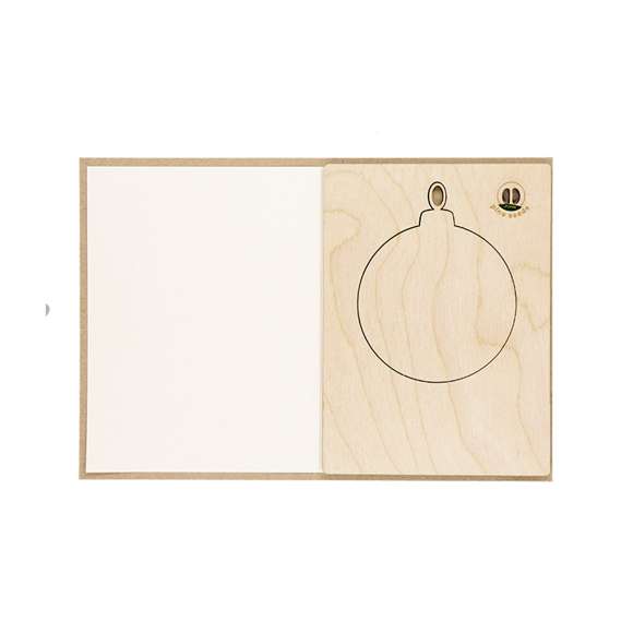 Sostenible y original set de postal navideña con adorno incluido en forma de bola de navidad y cápsula interior con semillas de pino, un regalo respetuoso con el medio ambiente a la vez que sorprendente. Contenido:Postal fabricada en papel de acabado Kraft. Bola de navidad de madera natural con troquelado en el interior. Cápsula de semillas de pino integrada en el interior.Elaborado con elementos vegetales para así fomentar la utilización de materias primas naturales y reducir las emisiones contaminantes.