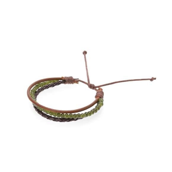 Pulsera confeccionada en piel, diseñada con la combinación de tres cordones: cuero marrón claro con acabado liso, central con cuentas de vidrio en color verde y un tercero de cuero trenzado marrón. Con cierre ajustable de suave algodón encerado. Presentada en cartón kraft con superficie lisa para el marcaje.