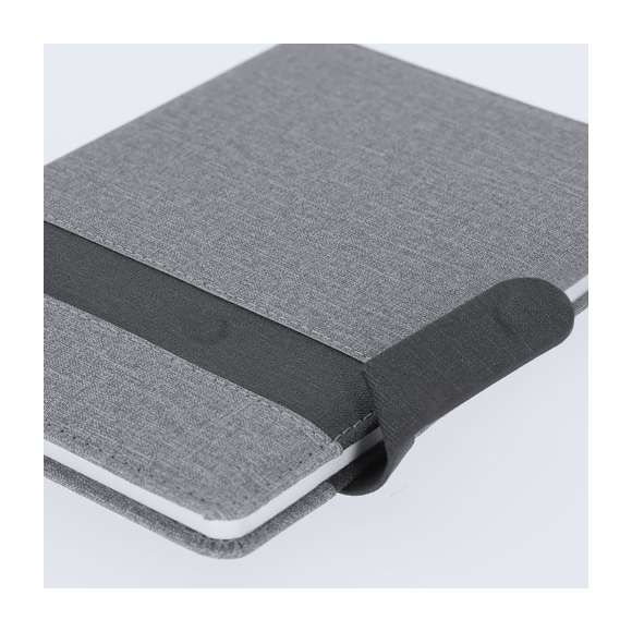 Bloc de notas A5 fabricado en PU. Elegante diseño gris con banda negra de cierre magnético a juego. Interior con 80 hojas color crema de disposición a una raya y marcapáginas de tela a juego.