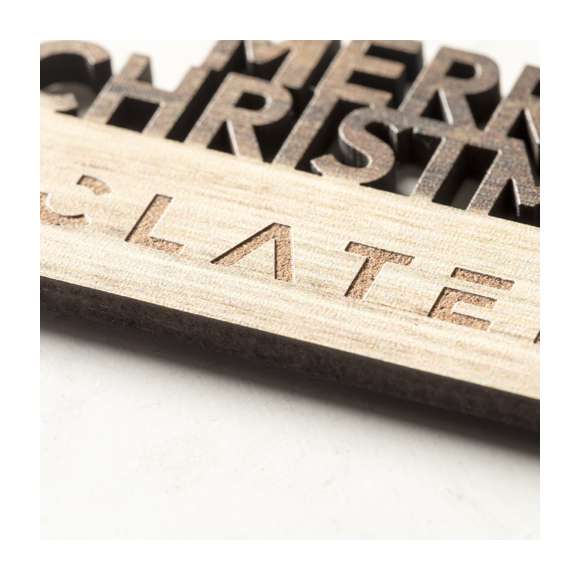 Original imán Merry Christmas fabricado en madera natural, con texto troquelado y de original acabado bicolor. Amplia superficie de marcaje y distintivo Made In Europe.