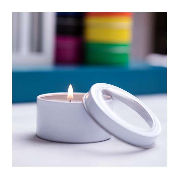 Vela aromática de fragancia vainilla presentada en original tarro metálico con ventana transparente en variada gama de vivos colores.
