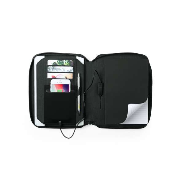 Completo organizador power bank en combinación de materiales poliéster 300D y polipiel. Cargador inalámbrico integrado en la portada, con soporte para sujeción del smartphone. Incluye batería auxiliar de 4.000 mAh de capacidad de carga integrada. De sobrio diseño y cierre de cremallera, incluye bloc de notas de 64 hojas con disposición a una raya, soporte para bolígrafo y tarjetero. Salida USB, con cable micro USB incluido y presentado en elegante caja negra. Las capacidades mostradas en todas nuestras baterías auxiliares externas son reales, incorporando todas ellas baterías de grado A y no recicladas, con una vida útil de al menos 500 ciclos de carga y según normativa CE. Además, están fabricadas conforme a los estándares RoHS y en cumplimiento con los siguientes requisitos de seguridad: Sistema de protección contra sobrecarga del power bank. Sistema de protección contra descarga completa que proporciona una mayor durabilidad del power bank. Sistema de bloqueo para evitar cor