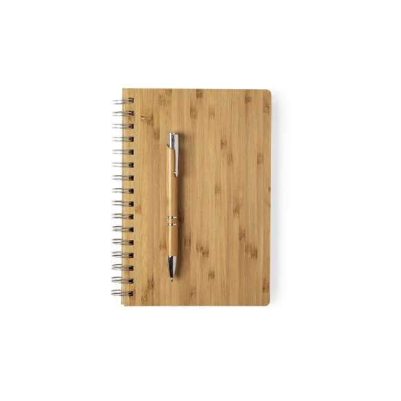 Set de libreta y bolígrafo en línea nature. Incluye libreta de anillas con tapas rígidas en bambú, con 80 hojas de disposición a una raya y diseño eco. Bolígrafo de mecanismo pulsador, con cuerpo en bambú y accesorios metálicos -cartucho jumbo y tinta negra-. Presentado en estuche de cartón troquelado y diseño eco.