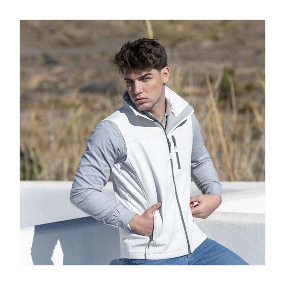 Chaleco impermeable y transpirable en material soft shell de 300g/m2. De elegante diseño bicolor, en color blanco con contraste de detalles en gris. Cierre de cremallera y bolsillos frontal y laterales de cremallera. Disponible en tallas S, M, L, XL, XXL.