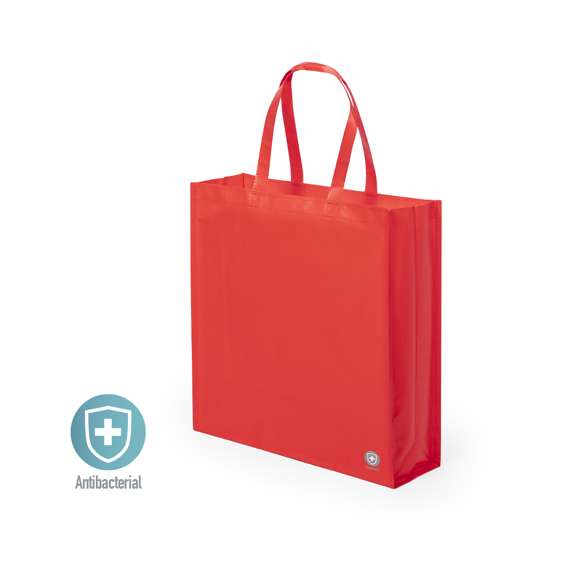Bolsa antibacteriana en PP-woven de alta resistencia y acabado mate. Disponible en variada gama de colores, con asas medianas reforzadas de 50 cm de largo. Acabado cosido, con fuelles y ribetes reforzados.  Los productos con tratamientos antibacterianos son capaces de reducir drásticamente las cargas bacterianas presentes en las superficies de los materiales, gracias a la incorporación de agentes microbianos permanentes estáticos, con alta efectividad para inhibir y prevenir la contaminación bacteriana.  Artículo de acuerdo al estándar ISO 22196, que determina la actividad antibacteriana en materiales plásticos y superficies no porosas, lo que permite conocer la efectividad de inhibición microbiana que tienen los aditivos sobre los objetos tratados mediante una evaluación cuantitativa.